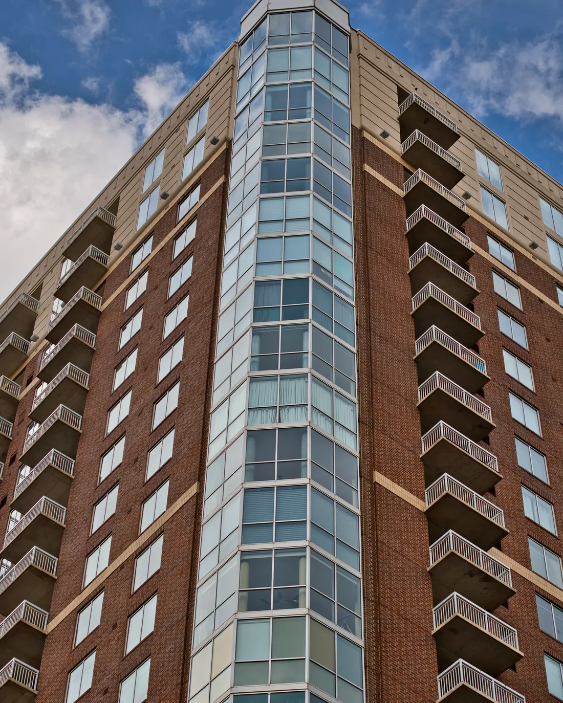 Esquina de torre residencial en ladrillo con ventanales de piso a techo — referencia de la suite ejecutiva en Miraflores